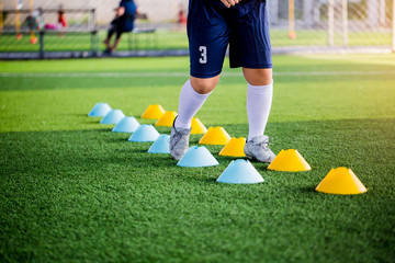 Young boy soccer players Jogging and jump between ladder drills for football training.