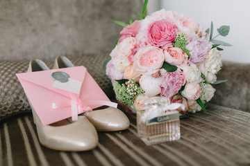 Details of the bride: shoes, pink bouquet, perfumes and invitations.