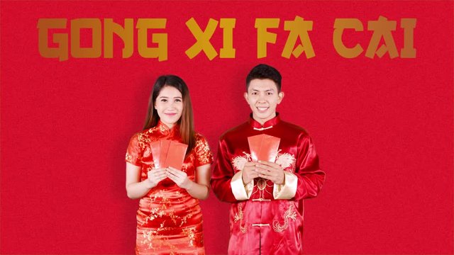 Chinese couple with red envelope celebrating Chinese new year over red background