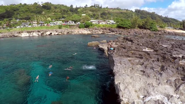Kids dive off of the cliffs at Shark's Cove on Oahu, Hawaii.