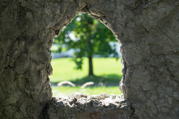 stone background with window and view of blurred green tree.
