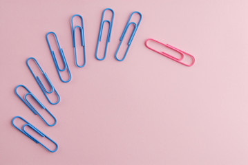 Colored paper clips on a pink background.