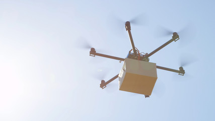 CLOSEUP LENS FLARE Drone delivery, aircraft flying brown package cargo over sun