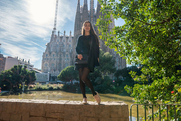 beautiful girl posing behind amazing gothic basilica church in europe . sightseeing and...