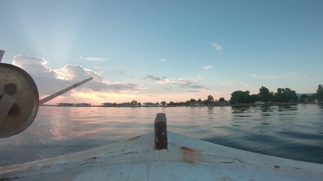 Point of view from inside of a sailing fishing boat. Sailing forward into the sunset. Calm water outside of Messolonghi in Greece.