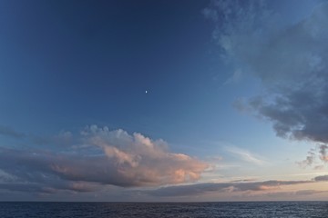 Thick white clouds over the horizon as the sun sets on the North Pacific Ocean between Sitka, Alaska, and Victoria, British Columbia, Canada.