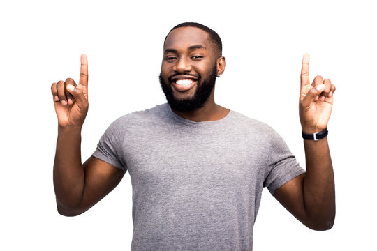 A pointing up confident and knowledgeable expert in his field consultant advises clients to turn their attention upwards. Black successful African American man. On white background in studio isolated