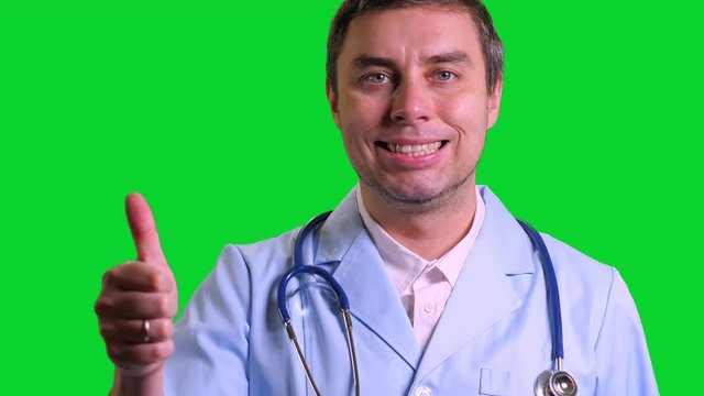 Young doctor stand and doing thumbs up on green chroma key background