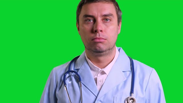 Young doctor stand and doing thumbs up on green chroma key background