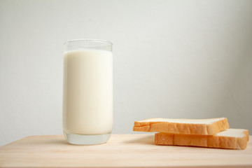 Milk with slices toast bread on wood background. 
