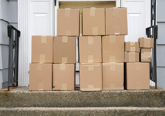 stacking delivered package boxes in front of the front door of house