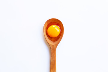 Chicken egg yolk on wooden spoon.