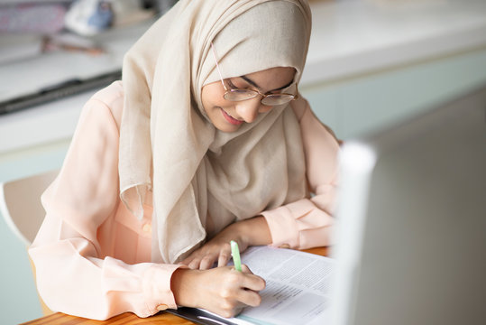 Asian Muslim Student Working With Computer In The Room.