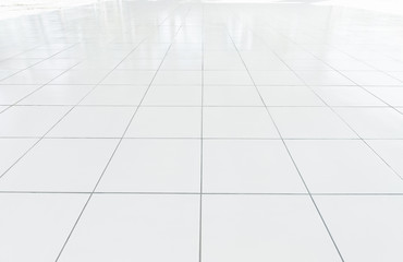 White tile floor background in perspective view. Clean, shiny, symmetry with grid line texture. For decoration in bathroom, kitchen and laundry room. And empty or copy space for product display also.