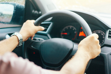 Driver with both hands at the wheel of the car