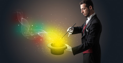 Illusionist hand starts to conjure with white glove and magic wand