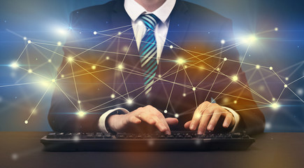 Businessman in suit typing with connection graphics around