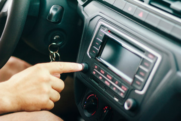 Fototapeta premium Driver turning on car sound while driving
