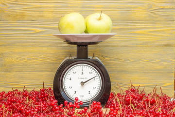 Тарелка с яблоками на механических весах.