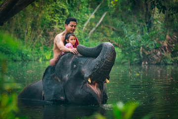 Happy dad and daughter sitting on the elephant, Thailand