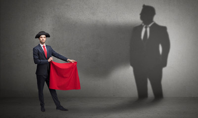 Businessman standing with red cloth on his hand and his shadow on the background
