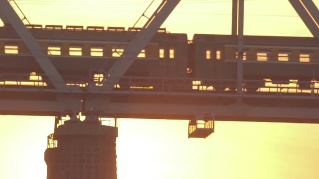 Train rides on an iron bridge at sunset