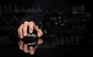 Hand using wireless mouse with financial concept on dark background
