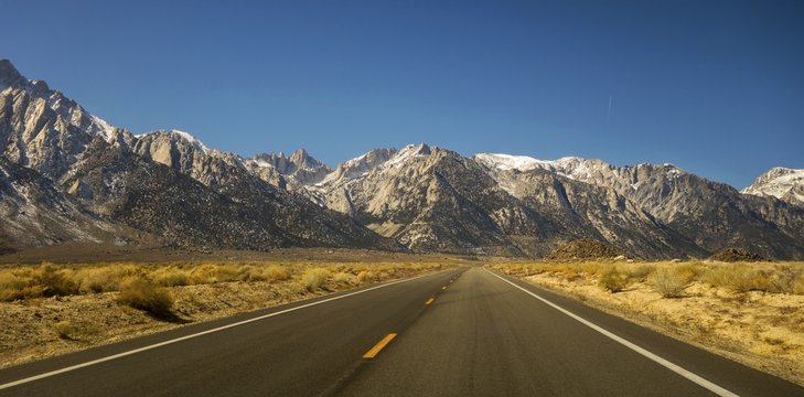 Driving Iconic California State Highway 395 in Owens Valley on Eastern Flanks of Sierra Nevada Mountains with Distant Mount Whitney on Horizon