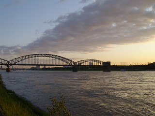 Fototapeta na wymiar Sonnenaufgang / Sonnenuntergang über dem Fluss (Rhein) und der Kölner Südbrücke