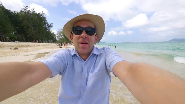 Happy man taking a selfie in Hawaiian beach in 4k slow motion  60fps