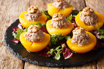 Peaches stuffed with mousse of canned tuna and walnuts, served with lettuce closeup. horizontal