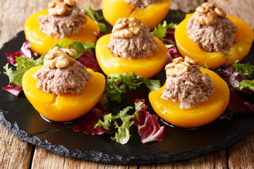 French appetizer of peaches stuffed with tuna mousse and walnuts close-up. horizontal