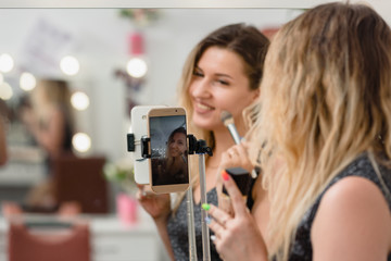 Professional beauty blogger broadcasting cosmetic makeup by smartphone