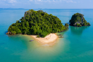 Aerial drone view of an exotic, tiny tropical island with sandy beach and jungle - obrazy, fototapety, plakaty