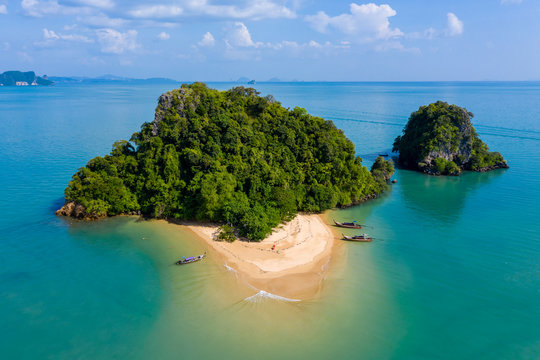 Aerial drone view of an exotic, tiny tropical island with sandy beach and jungle