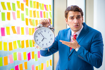 Young handsome employee with many conflicting priorities   