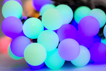Soft colorful bokeh background. Luminous garlands of electric lights. Saturated colors. Blurry abstraction. Gentle tone. Dark night. Festive party in city. Defocus effect.