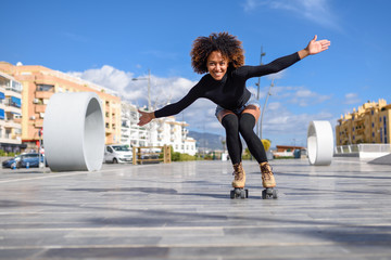 Black woman on roller skates riding outdoors on urban street