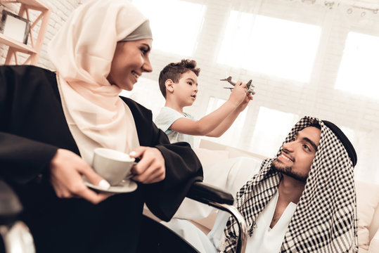 Arabian Woman on Wheelchair with Cup with Family.
