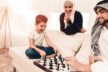 Arabian Boy Playing Chess with Father at Home.