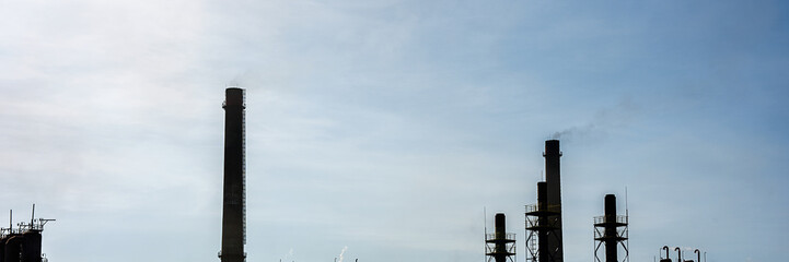 Silhouettes of industrial pipes and sky