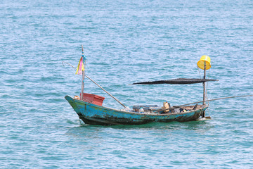 Fototapeta na wymiar Fishing boat floating on the water, blue sea with copyspace