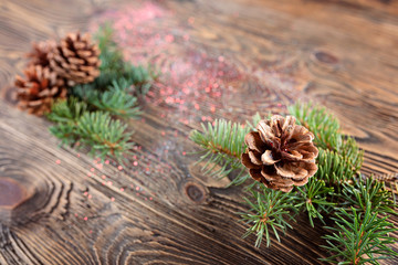 Christmas composition from branches of spruce and cones on a wooden background. Rustic style. Bokeh