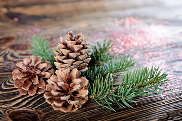 Christmas composition from branches of spruce and cones on a wooden background. Rustic style. Bokeh