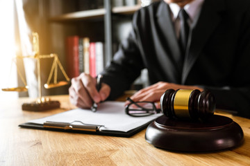 justice and law concept.Male judge in a courtroom  the gavel, working with smart phone and laptop...
