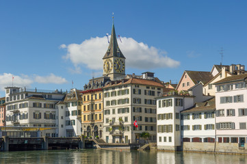 the St. Peter Church tower  and old houses along the Limmat river, Zurich, Switzerland
