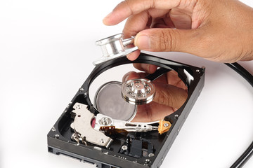 RECOVERY AND REPAIR TECHNOLOGY CONCEPT: Hard Disk Drive (HDD) with stethoscope isolated on white.