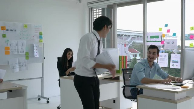Businessman working with desktop and feeling excited. Business man throwing report paper with delight. Concept of business success.