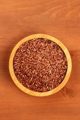A photo of flax seeds, shot from the top on a dark rustic background with copy space