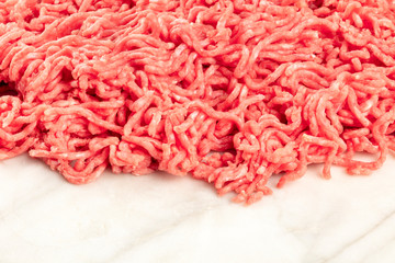 A photo of minced meat on a white marble background with a place for text